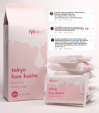 A package of Ryxskin Sincerity Tokyo Luxe Bathe with a bar of soap visible in front of the box. The box is pink with product information text.