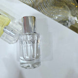 Two perfume bottles on a white surface with a decorative background