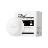 TeaShell Amide Skin Brightening Soap shown as a round white bar of soap in front of its white and black retail box on a plain white background.